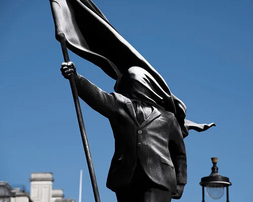 Banksy just put a faceless suit carrying a flag outside London's most famous landmarks and yeah, it tracks